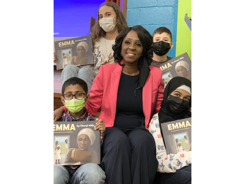 a woman sitting with kids holding posters